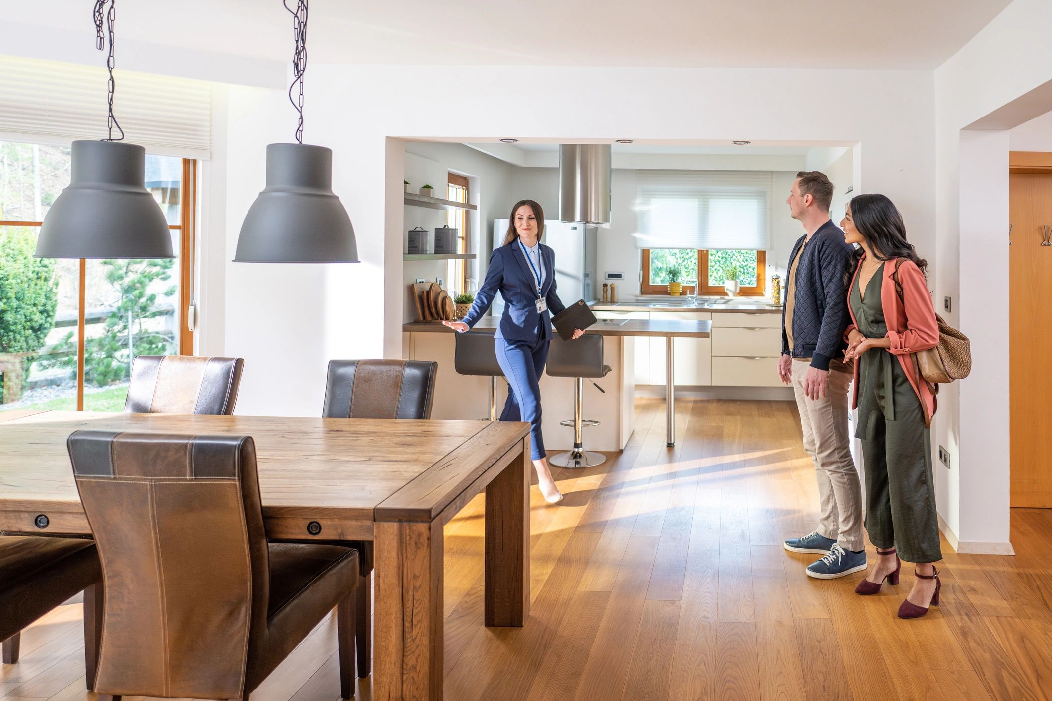 Homeowners reviewing remodeling ideas with a property professional in a bright kitchen